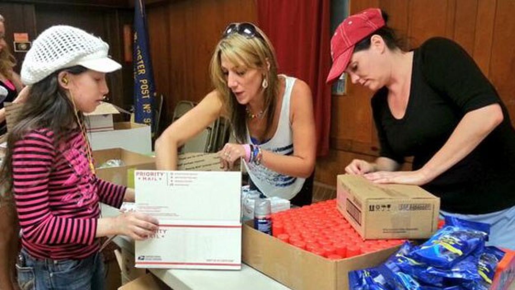 Heartillery Group and Hero Helpers of America combine efforts to form a care package production line at the American Legion Hall in Foxboro